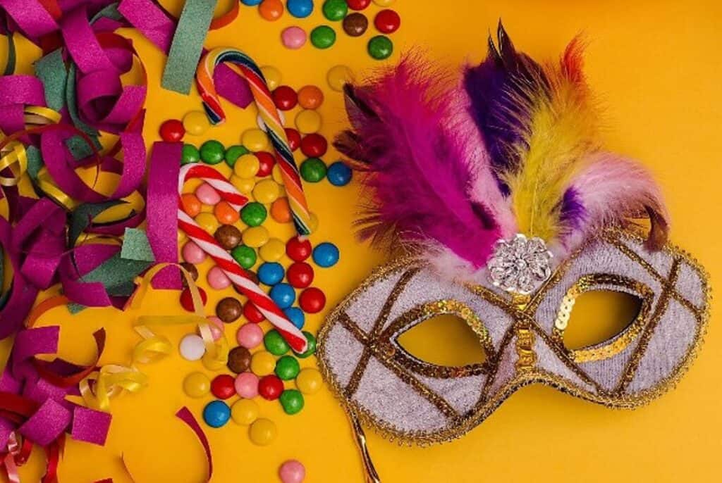 Colorful carnival mask with feathers and confetti for festivities.
