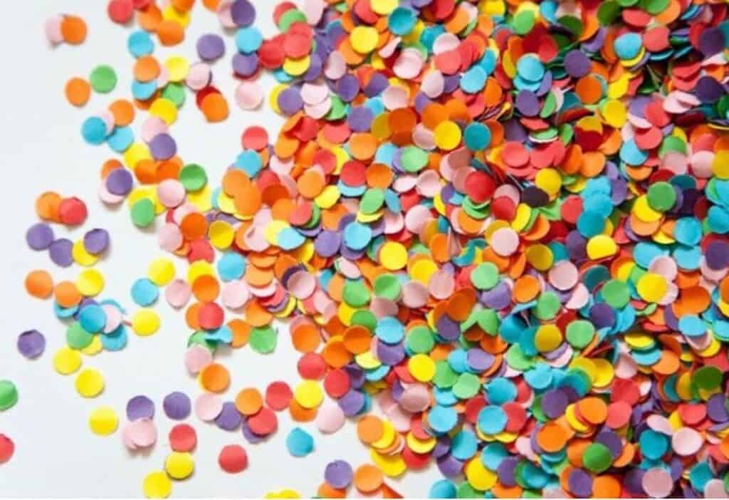 Confetes coloridos dispersos em fundo branco para celebração e diversão brasiliense.