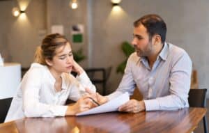 Duas pessoas conversam e analisam um documento.